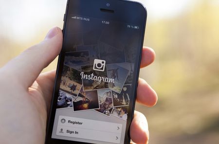 Nizhnevartovsk, Russia - June 12, 2013: Man hand holding iPhone 5 with Instagram App. iPhone is product Apple Inc. Instagram is an online photo-sharing and social networking service.