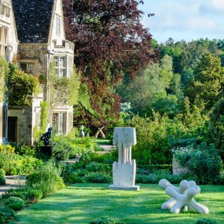 Exterior of Asthall Manor in the Cotswolds with On Form sculpture exhibition in its grounds