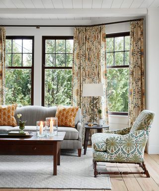 living room with patterned chairs and bay window