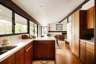 Walnut cabinets and cork floors evoke the simple material approach of the 50s