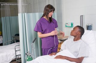 female nurse looking after a male patient in bed
