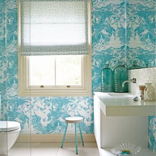 bathroom with green wallpaper and basin with stool