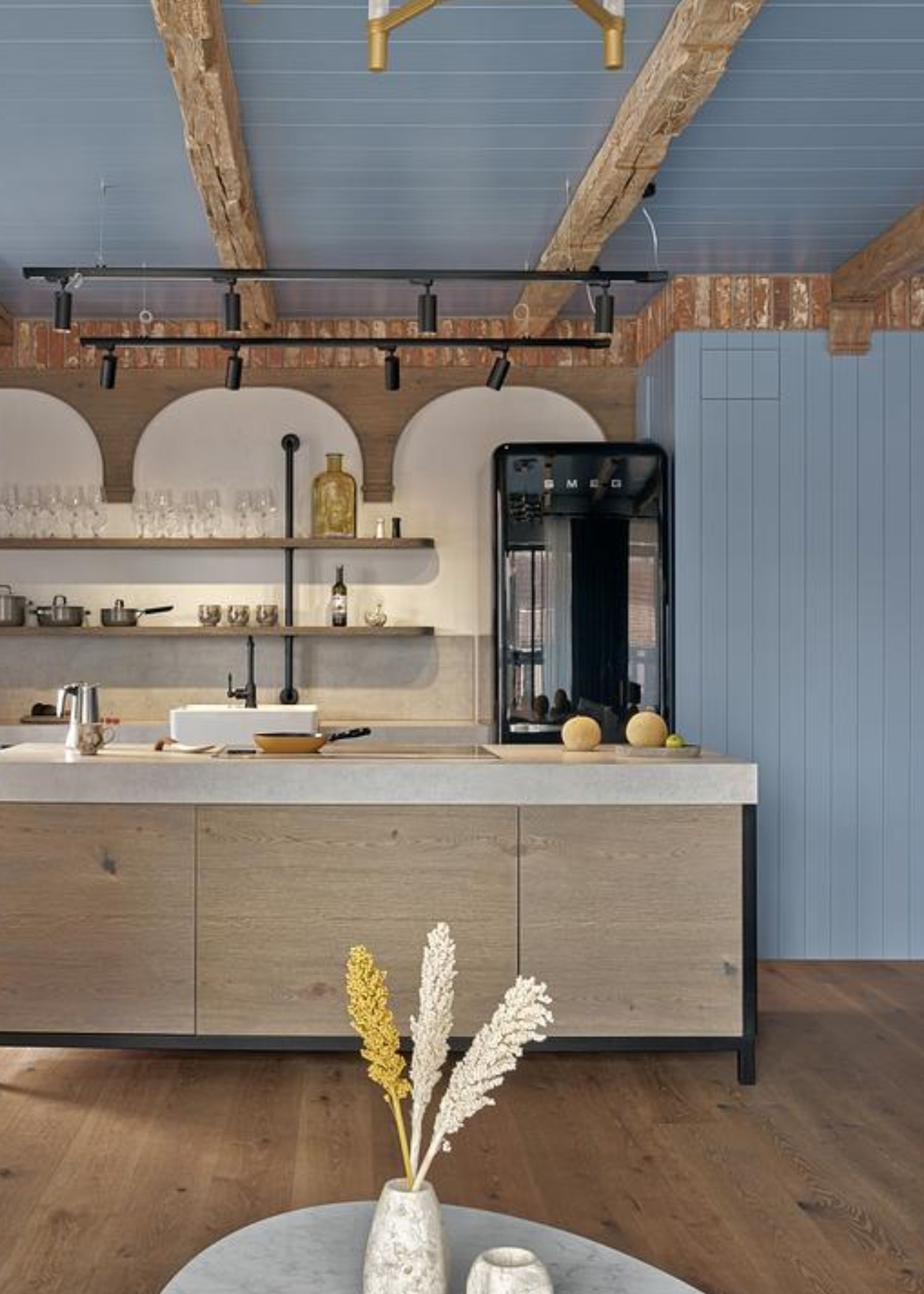 A kitchen painted in blue with an oak island in the middle. There is also a black colored retro fridge in the kitchen, as well as a view of open shelving with glassware on top