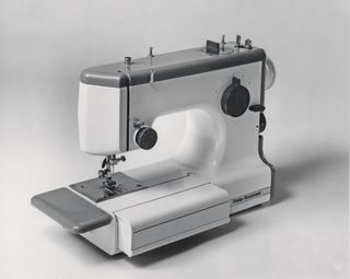 This photograph of the Cub 3 sewing machine demonstrates the fold-out surfaces, with the front segment also doubling as storage for accessories.