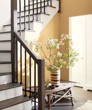 yellow hallway and stairwell with wooden banisters and stair treads