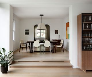 dining room with white walls and steps up