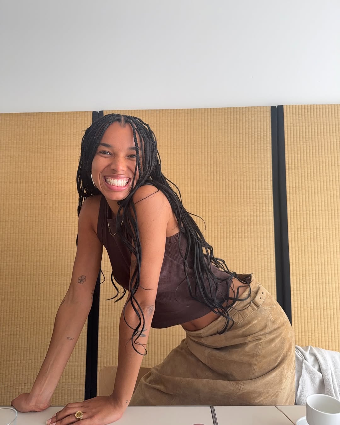 Fia wears brown suede skirt and tank top