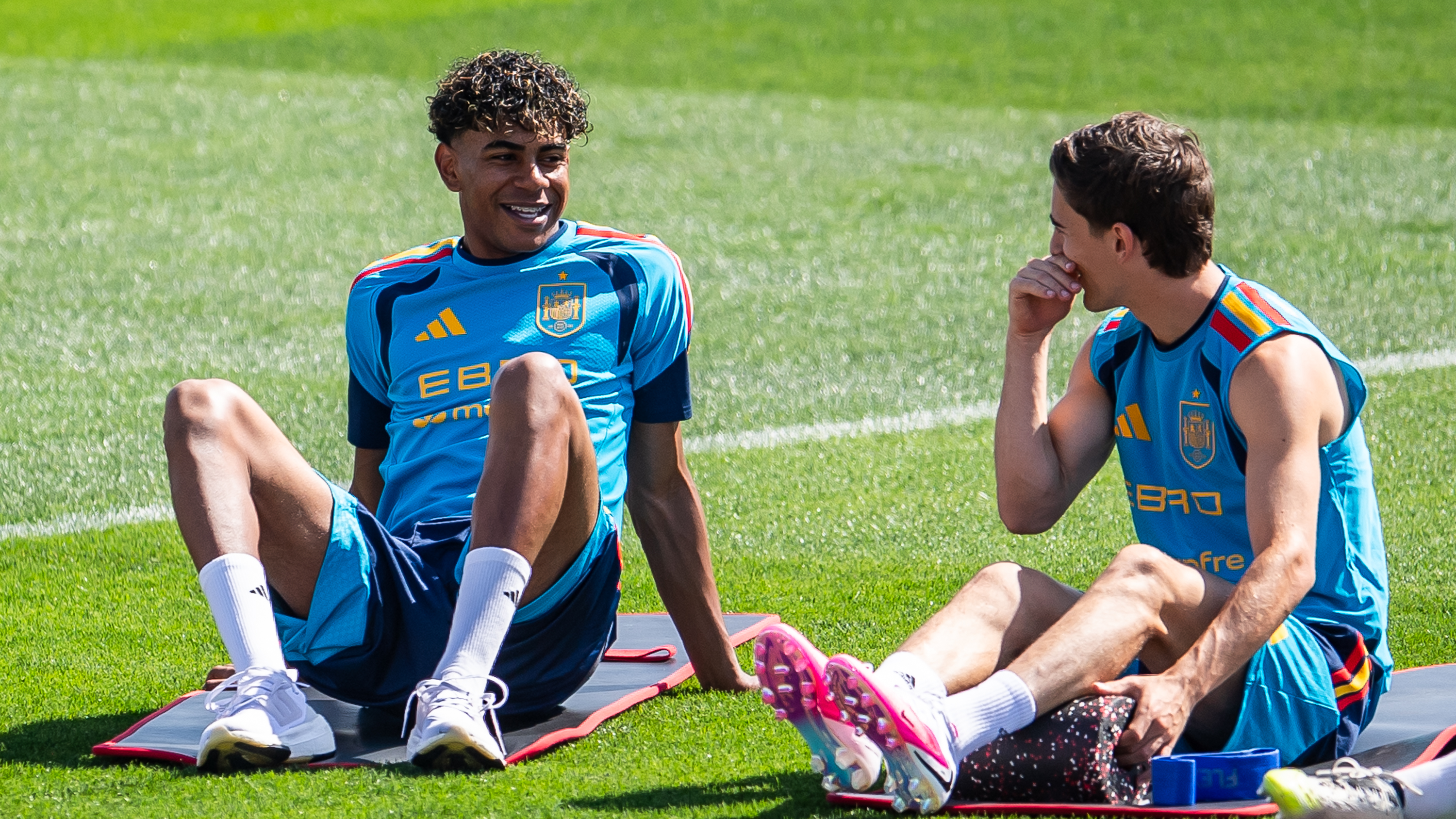 Lamine Yamal talks to Gavi of Spain during a training session