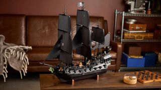 Lego Captain Jack Sparrow's Pirate Ship kit, fully built, on a coffee table in front of shelves and a leather sofa