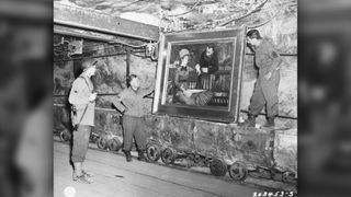 Two GI's examine the painting "Wintergarden," by French impressionist Edouard Manet. It was among the collection of art treasures looted by the Nazis and found by American forces in a salt mine in Merkers, Germany in 1945.