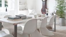 All white dining room with statement chair and vintage clock