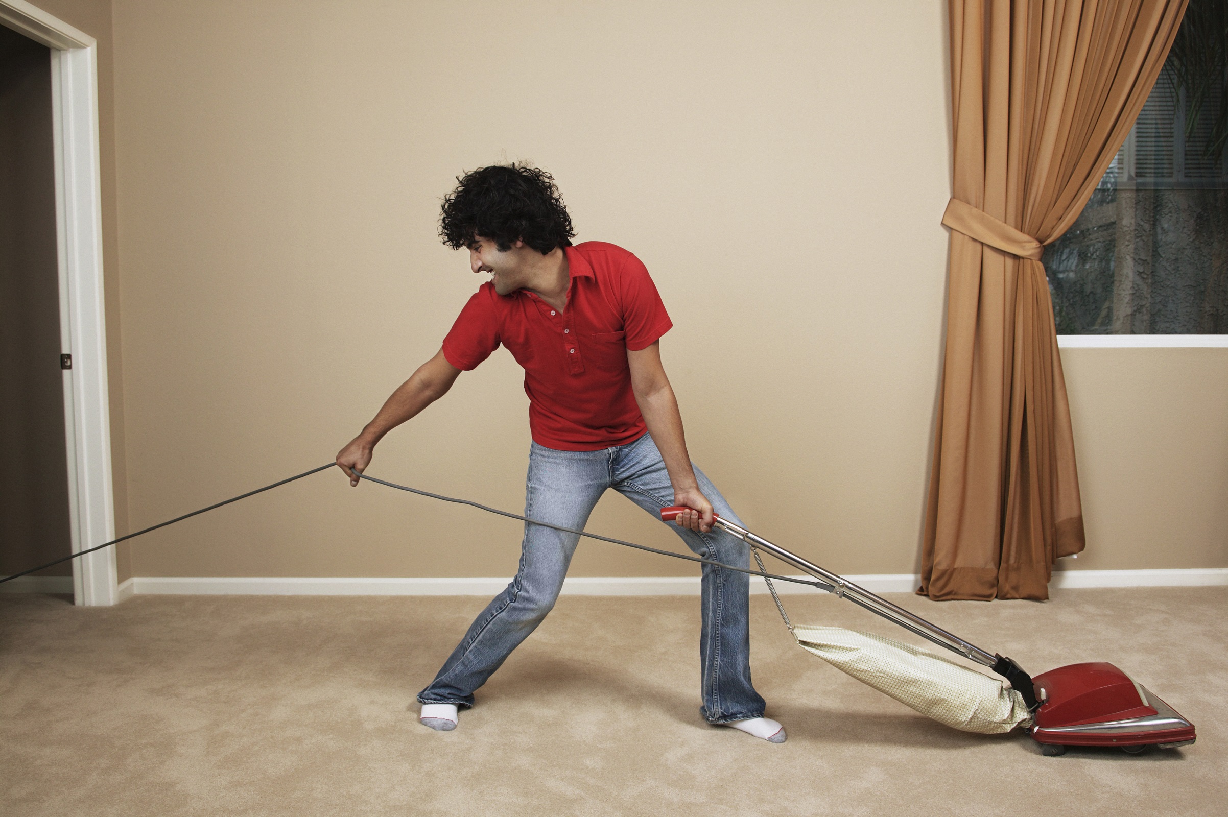 man pulling cable of vacuum cleaner