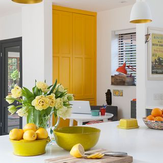 kitchen with white worktop and yellow cupboard