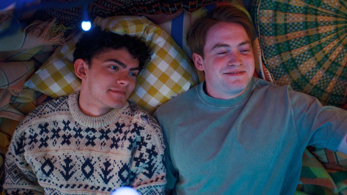 Nick and Charlie lie on a bed