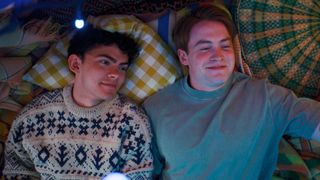 Nick and Charlie lie on a bed