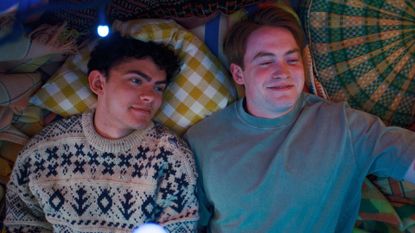 Nick and Charlie lie on a bed