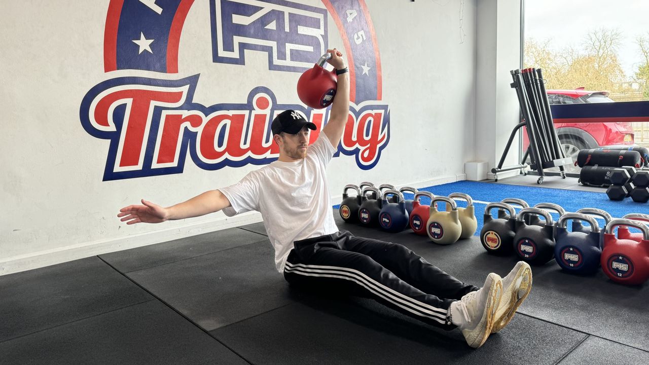 F45 personal trainer demonstrates a single arm crunch