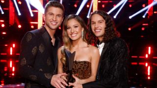 The Voice Season 21 winners Girl Named Tom are shown with their trophy.