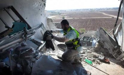 An Israeli Zaka emergency services volunteer works in an apartment that was hit by a rocket fired by Palestinian militants, killing three people on Nov. 15 in Kiryat Malachi, Israel.