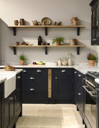 Dark kitchen with open shelving and built in space for trays
