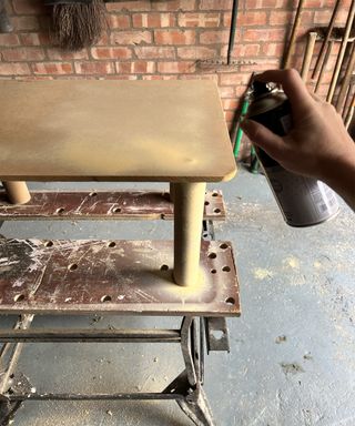 Hand spraypainting home made table cream with a spray can