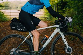 Male cyclist wearing gloves while riding on gravel