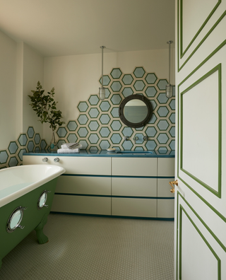 family bathroom with green bath tub and blue hexagonal tiles