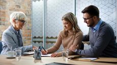 A financial adviser helps a couple manage their finances.