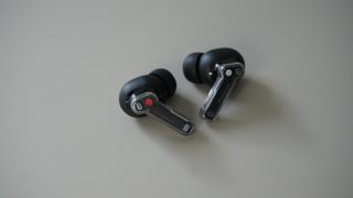 The Nothing Ear wireless earbuds in black on a grey background