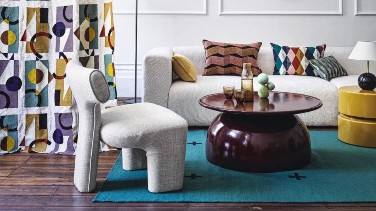 Grey chair and sofa, red coffee table, blue rug