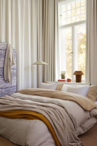H&M Home bedding and textiles layered in a cozy bedroom