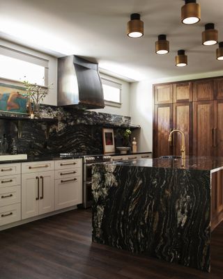 dark marble kitchen with gold spotlightd
