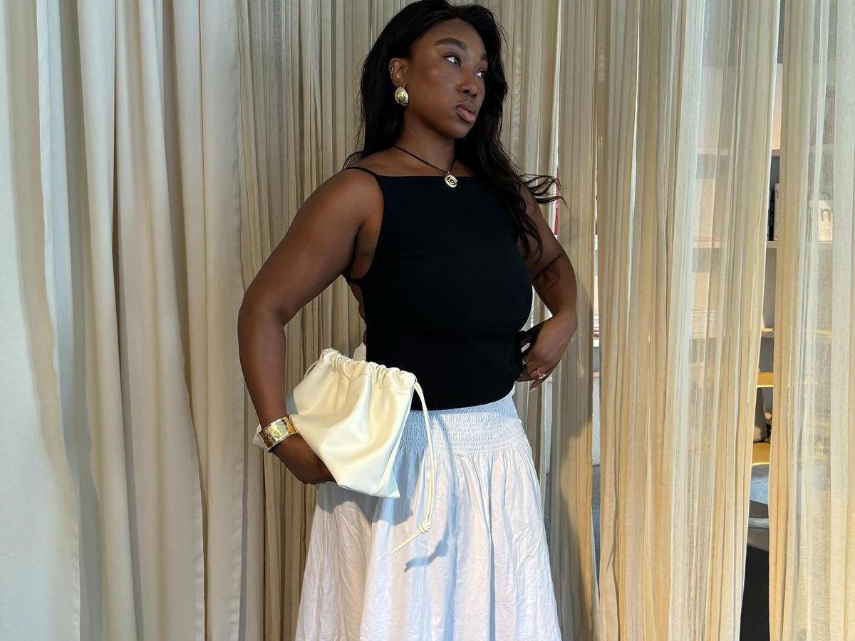 Influencer @nnennaechem wears a white long skirt, a black top, and a necklace.