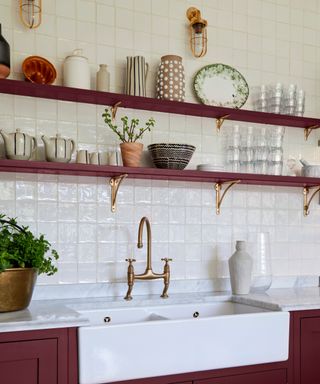 red shelving in utility room with gold brackets