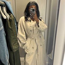 Remi wears the Arket garment-dyed trench coat 