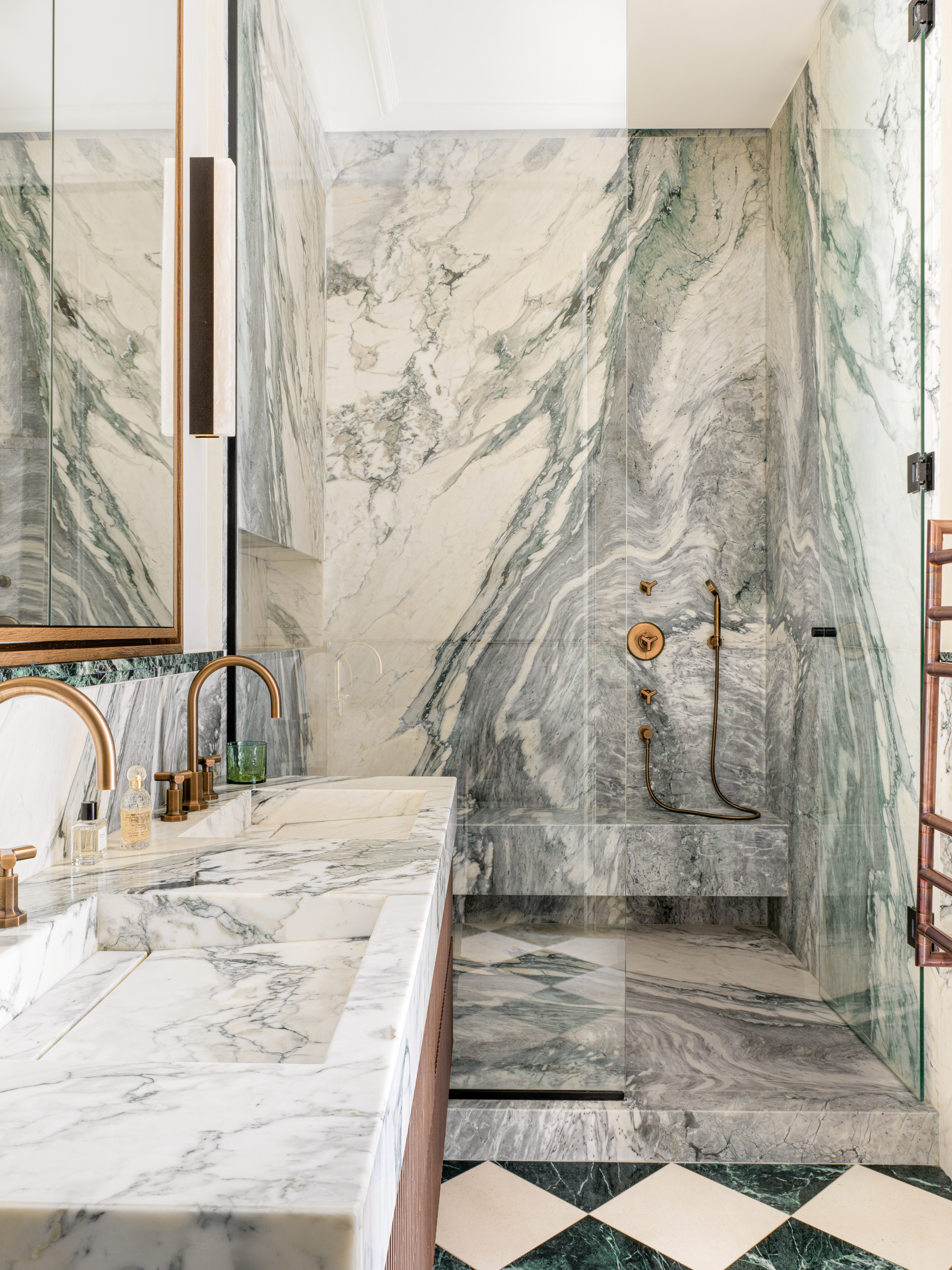 Bathroom with green-veined marble surfaces and shower with built-in seat