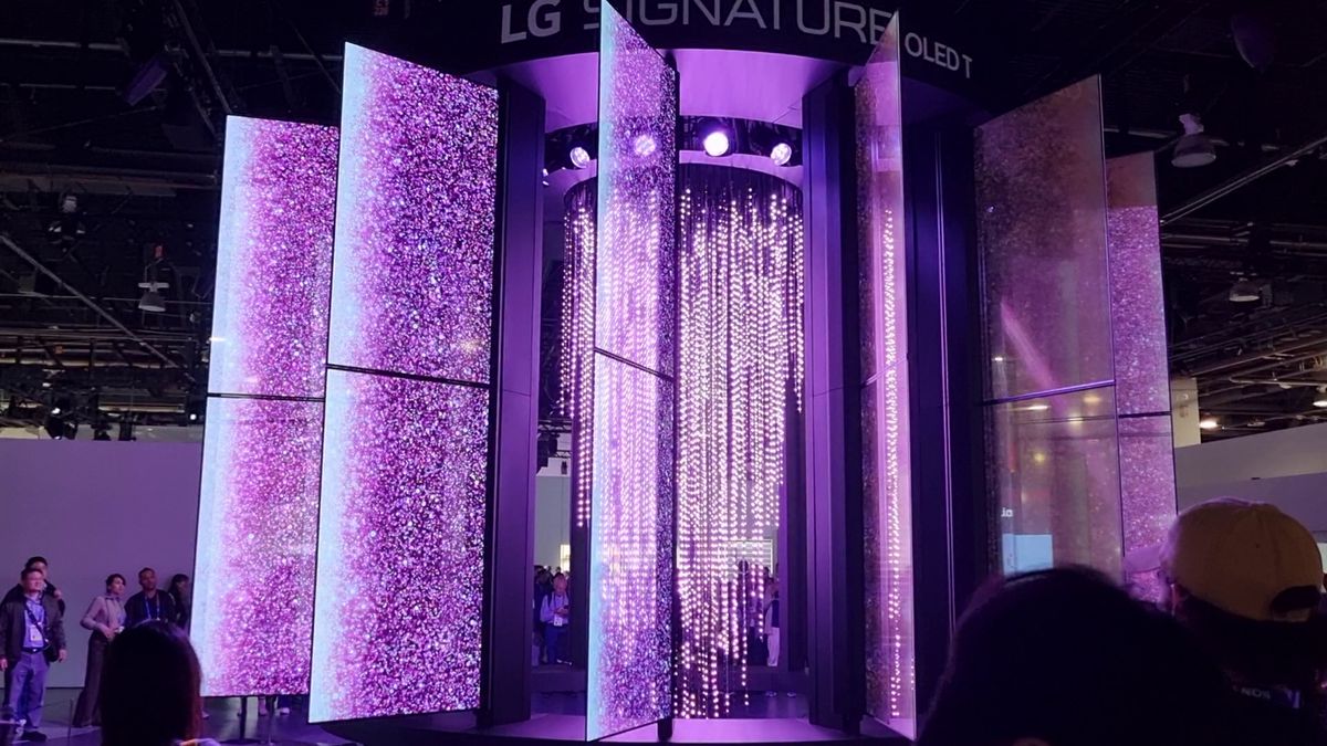 A display at CES 2025 showing several huge transparent screens mounted and motorised around a chandelier, lit up in purple.