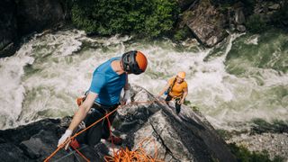 Two climbers on a route over a river
