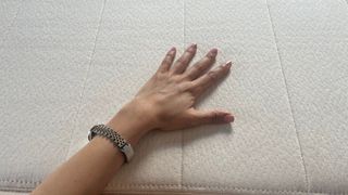Birch Natural mattress with reviewer's hand on it