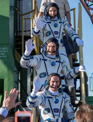 Expedition 52 flight engineer Randy Bresnik of NASA, top, flight engineer Paolo Nespoli of ESA (European Space Agency), middle, and flight engineer Sergei Ryazanskiy of Roscosmos wave farewell before boarding their Soyuz MS-05 spacecraft for a launch to the International Space Station from Baikonur Cosmodrome, Kazakhstan on July 28, 2017.