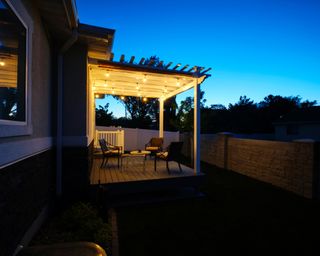 A backyard of a suburban USA home with a deck and pergola.