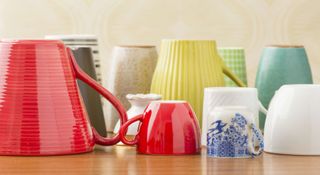 An assortment of different shaped and colored mugs