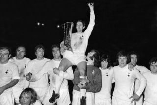 Tottenham captain Alan Mullery sits on the shoulders of his team-mates as he holds the UEFA Cup after Spurs' win in the final against Wolves in May 1972.