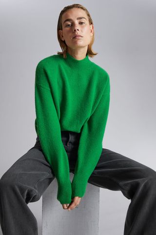 cold weather glothing - woman wearing green high neck jumper