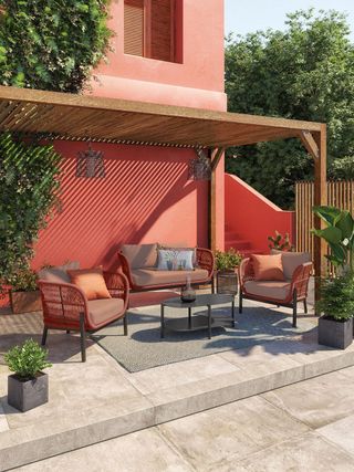 red garden furniture under a pergola