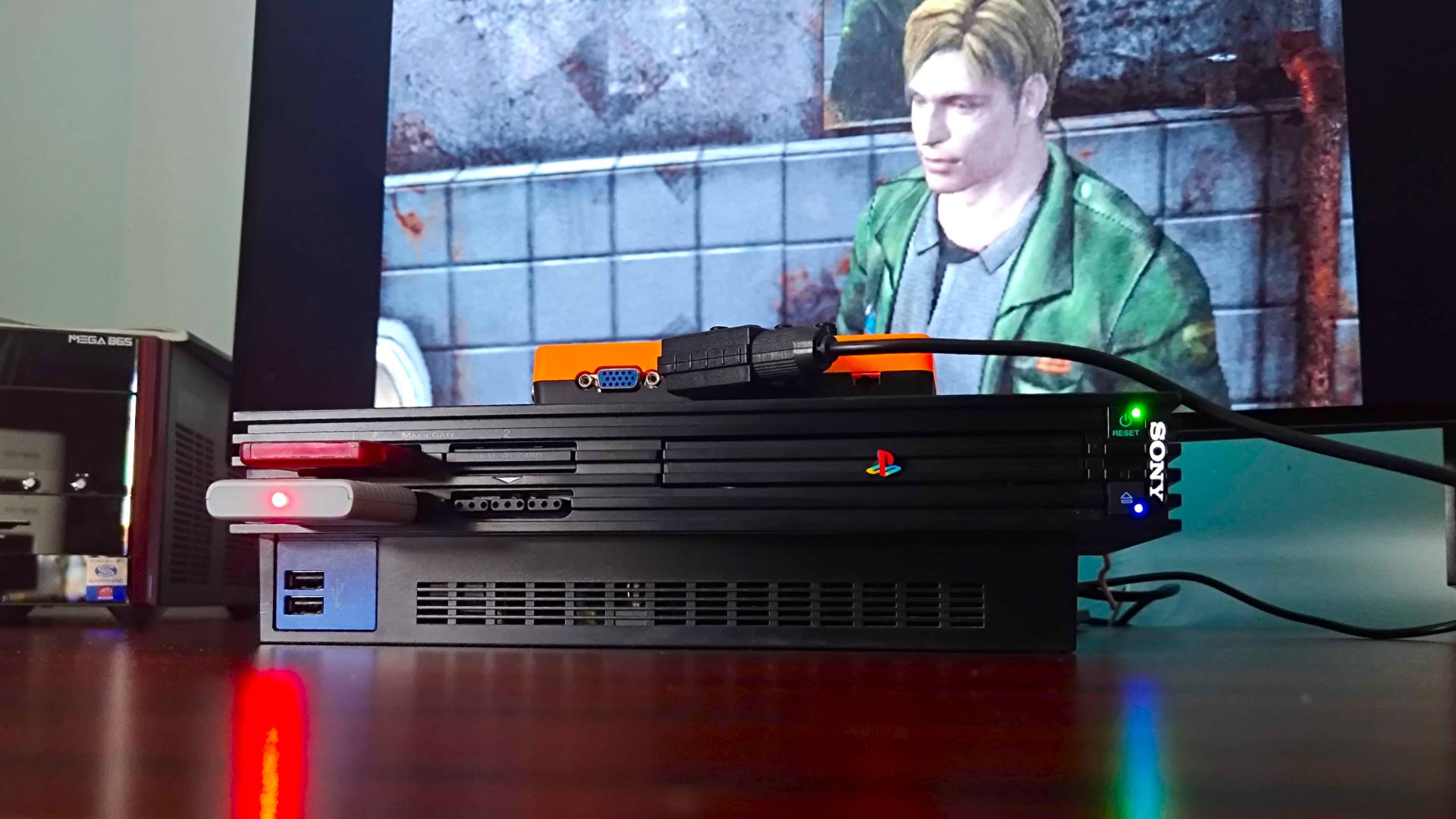 PS2 console with GBS-C upscaler connected via SCART and sitting on top with James from Silent Hill 2 on screen in backdrop.