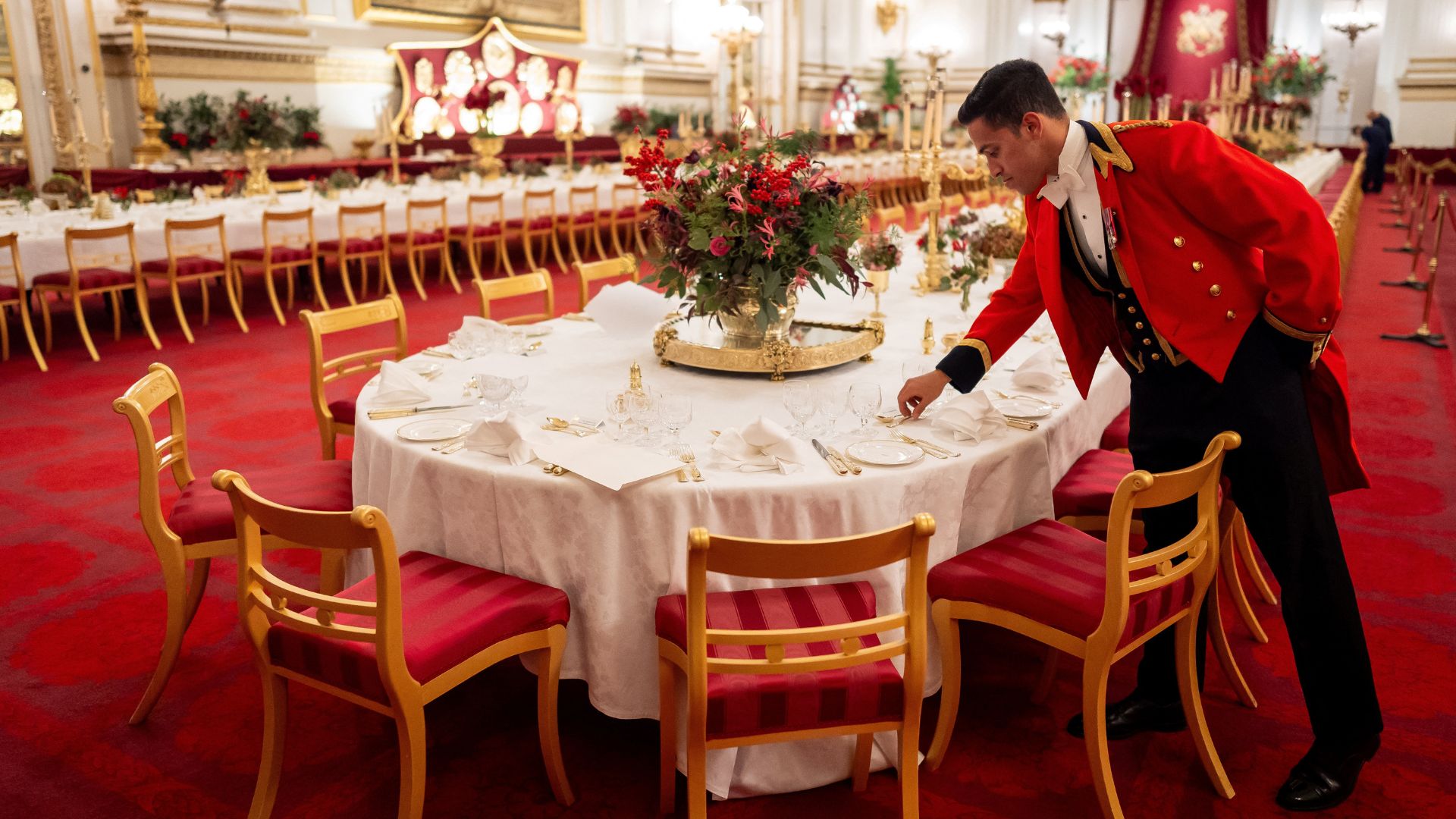 A palace staff member sets a table in Buckingham Palace