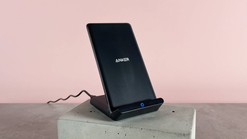 The Anker 313 Charger Stand is angled slightly to the right. It&#039;s sitting on a cement block against a pink background.