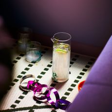 IKEA &Ouml;MSESIDIG collection glass carafe next to colourful decorations