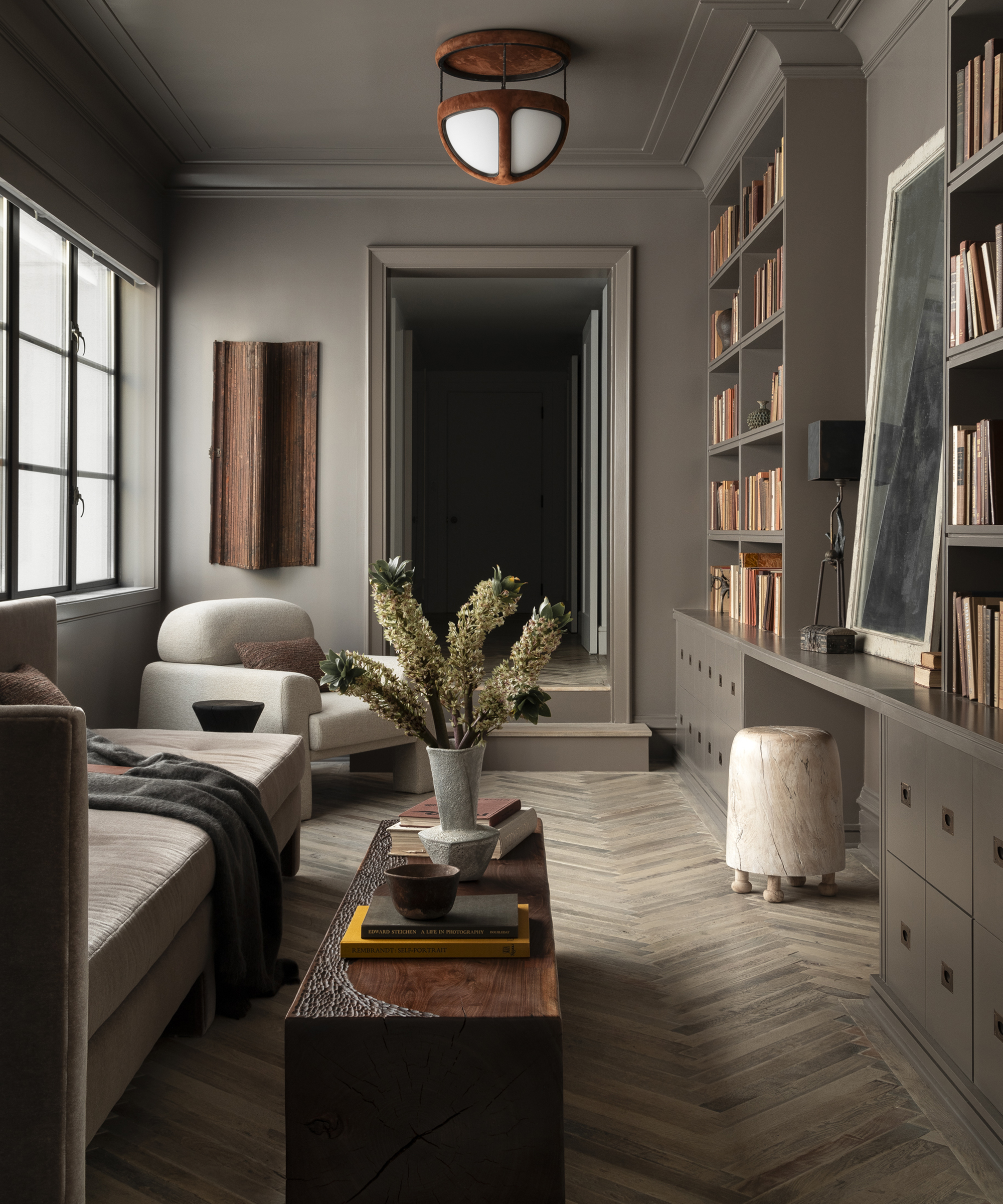 dark snug with light furniture and bookshelves along one wall